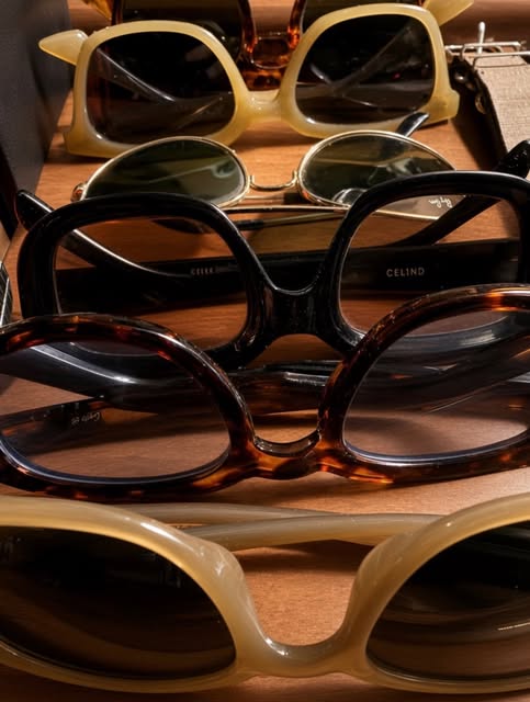 A stack of sunglasses, from thick acetate frames to thin metal aviators