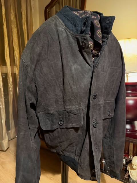 Dark suede jacket layered over a patterned shirt